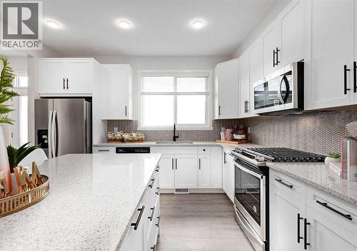 PLEASE NOTE: Photos are of a Showhome of the same model – fit & finish may differ. Interior selections & floorplans shown in photos - 162 Lanark Gate Se, Airdrie, AB - Indoor Photo Showing Kitchen With Upgraded Kitchen