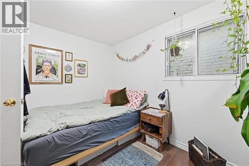 Bedroom with dark wood-type flooring and baseboards - 18 Fraser Avenue, Hamilton, ON - Indoor Photo Showing Bedroom