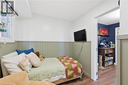 Bedroom with a wainscoted wall and wood finished floors - 18 Fraser Avenue, Hamilton, ON - Indoor Photo Showing Bedroom