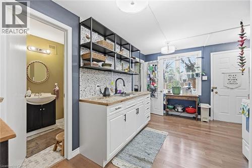 Bar with white cabinets, tasteful backsplash, open shelves, light wood-style floors, and white range oven - 18 Fraser Avenue, Hamilton, ON - Indoor