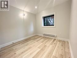 Unfurnished room featuring light wood-style flooring and a baseboard radiator - 