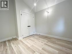 Unfurnished bedroom featuring light wood-type flooring, lofted ceiling, and a closet - 