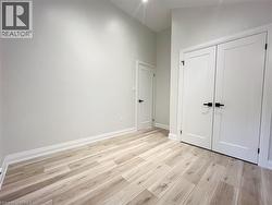 Unfurnished bedroom with light wood finished floors, a closet, and high vaulted ceiling - 