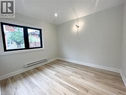 Unfurnished room with a baseboard radiator and light wood-style floors - 