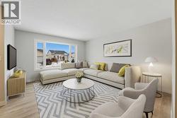 The spacious living room, located to the left of the entrance, is filled with natural light from a large front-facing window - 