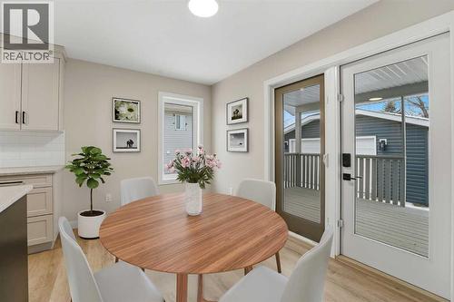 The dining area overlooks the backyard and deck through patio doors - 82 Bruns Crescent, Lacombe, AB - Indoor Photo Showing Dining Room