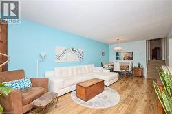 Living room with wood finished floors, wood walls, and an accent wall - 