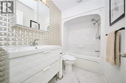Full bath with bathtub / shower combination, vanity, and light marble finish floors - 