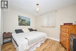 Bedroom with light wood-type flooring and baseboards - 