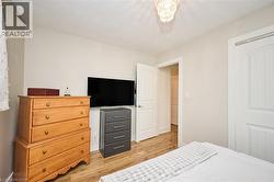 Bedroom featuring light wood finished floors and a textured ceiling - 