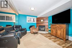 Living room featuring a large fireplace, light wood-type flooring, and a textured ceiling - 