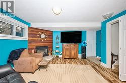 Living area featuring wood finished floors and a large fireplace - 