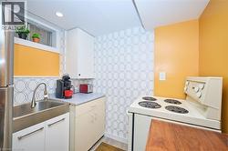 Kitchen featuring white range with electric stovetop, white cabinetry, freestanding refrigerator, light countertops, and tasteful backsplash - 