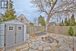 Fenced backyard featuring a patio and a storage shed - 