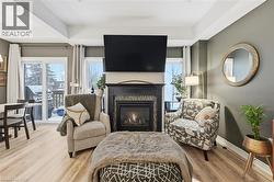 Sitting room with a glass covered fireplace, wood finished floors, and plenty of natural light - 