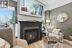 Living area with wood finished floors and a glass covered fireplace - 