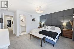 Bedroom with light colored carpet and a decorative wall - 