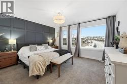 Bedroom featuring a decorative wall and light carpet - 