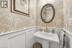 Bathroom with a decorative wall, wallpapered walls, and a wainscoted wall - 