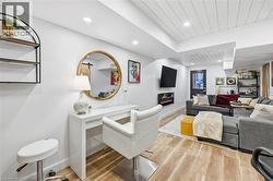 Living area featuring light wood-type flooring, a glass covered fireplace, and recessed lighting - 