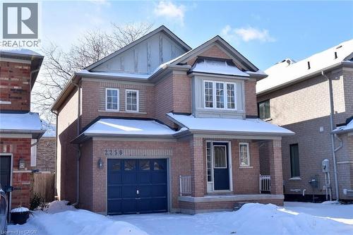 View of front of home featuring brick siding, a garage, and board and batten siding - 2258 Empire Crescent, Burlington, ON - Outdoor With Facade