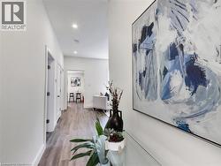 Hall featuring baseboards, light wood-style floors, and recessed lighting - 