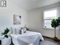 Bedroom featuring baseboards, visible vents, and wood finished floors - 