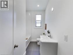 Bathroom with tile patterned floors, vanity, toilet, and baseboards - 