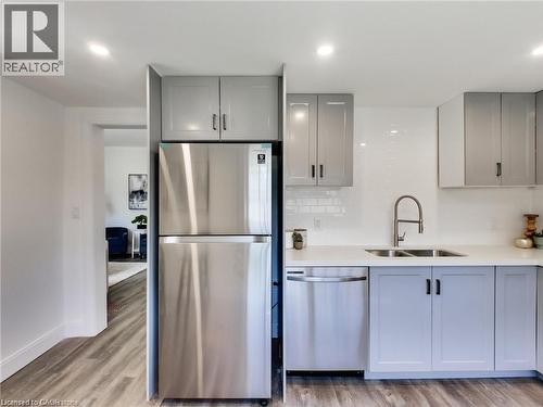 Kitchen featuring a sink, stainless steel appliances, and gray cabinets - 54 Fairview Avenue, Hamilton, ON - Indoor Photo Showing Kitchen With Double Sink