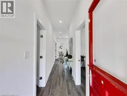 Hall featuring baseboards, wood finished floors, and recessed lighting - 