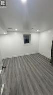 Finished basement with dark wood-style flooring and recessed lighting - 