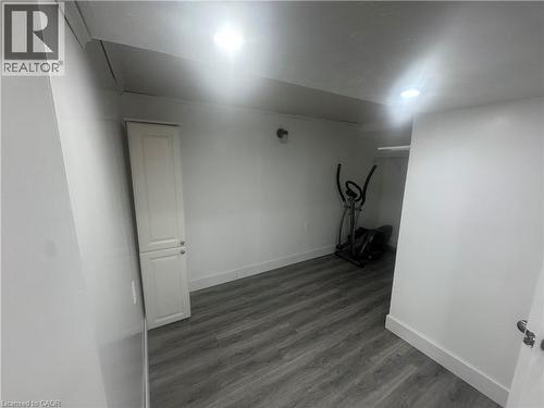 Unfurnished room featuring baseboards and dark wood finished floors - 18 Ingleside Drive, Kitchener, ON - Indoor