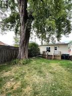 Back of property featuring a fenced backyard and a wooden deck - 