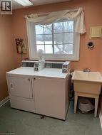 Laundry room featuring baseboards and washing machine and clothes dryer - 