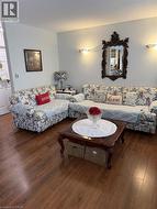 Living room featuring wood-type flooring and a textured ceiling - 