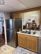 Kitchen with brown cabinets, light countertops, and appliances with stainless steel finishes - 