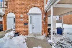 Snow covered property entrance featuring brick siding and heating fuel - 