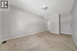 Unfurnished bedroom with light carpet, a textured ceiling, and a closet - 