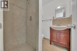 Full bath featuring a shower stall, vanity, light tile patterned flooring, and tasteful backsplash - 