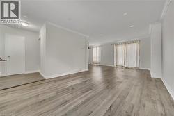 Unfurnished room with crown molding and light wood-style floors - 