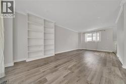 Empty room with ornamental molding and light wood-style flooring - 