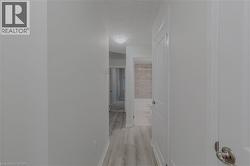 Corridor with baseboards, light wood-type flooring, and a textured ceiling - 