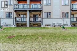 Back of property with brick siding, ac unit, and a yard - 