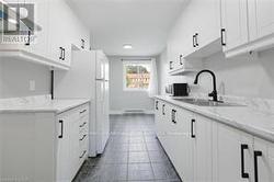 Kitchen with sink, white cabinetry - 