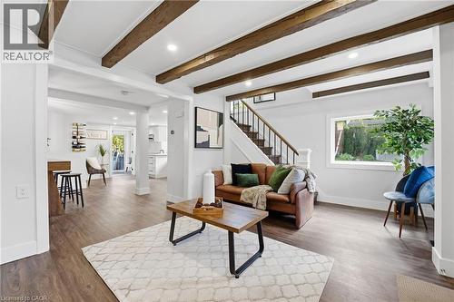 Living area with recessed lighting, beamed ceiling, dark wood-type flooring, and stairs - 4255 William Street, Beamsville, ON - Indoor Photo Showing Living Room