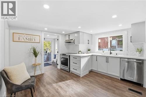 Kitchen featuring backsplash, stainless steel appliances, light wood-style floors, recessed lighting, and under cabinet range hood - 4255 William Street, Beamsville, ON - Indoor Photo Showing Kitchen With Upgraded Kitchen