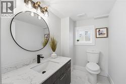 Half bathroom with vanity and light marble finish flooring - 