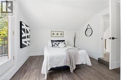 Bedroom with dark wood-type flooring and lofted ceiling - 