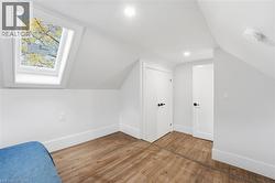 Additional living space featuring lofted ceiling, light wood-type flooring, a skylight, and recessed lighting - 