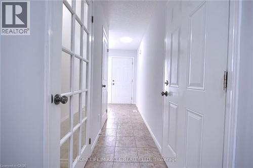Hallway featuring a textured ceiling and light tile patterned floors - 919 Zeller Crescent, Kitchener, ON - Indoor Photo Showing Other Room